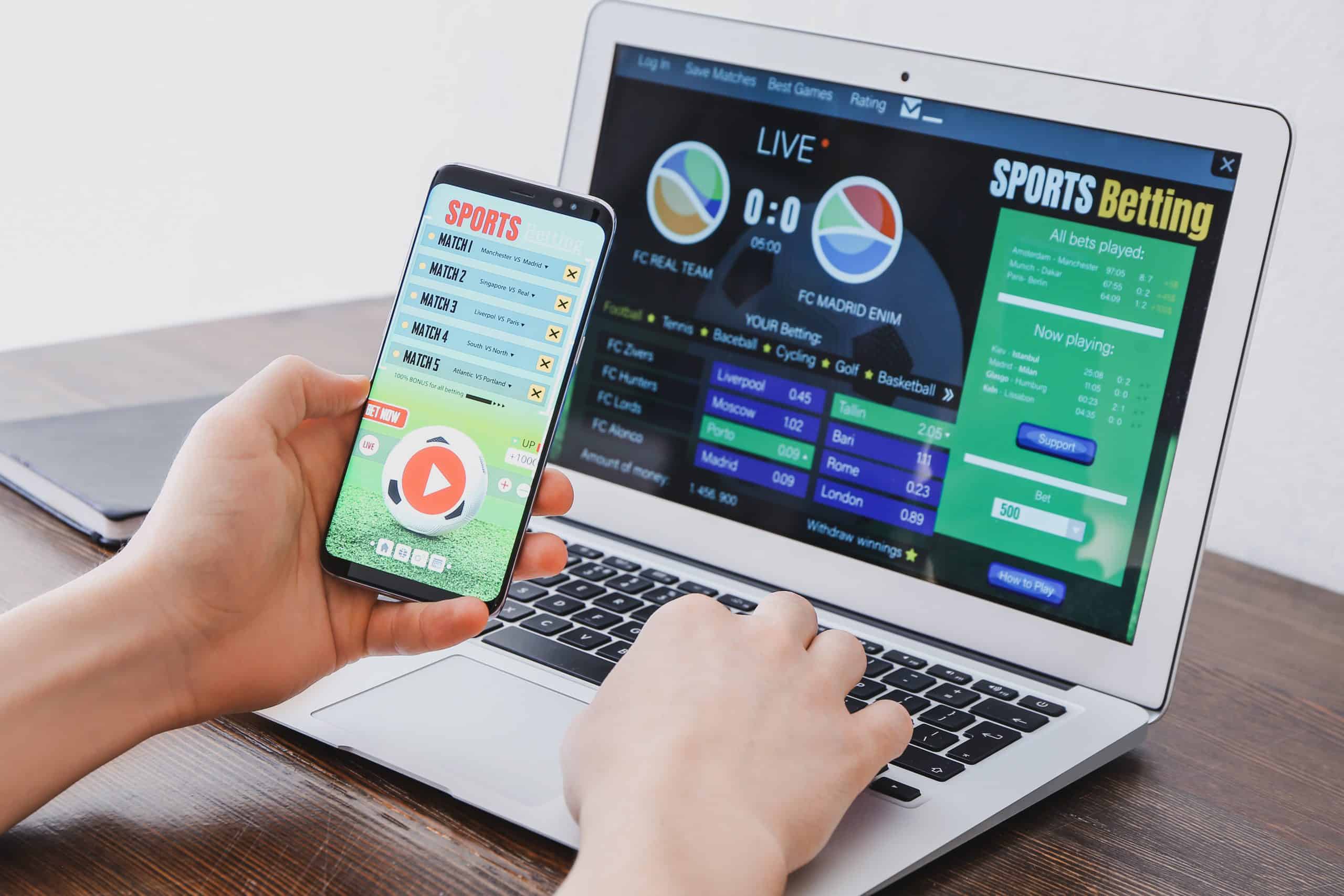 Man placing single bet on a mobile and lapop